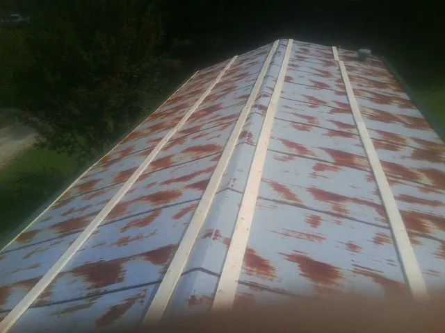 Rusted metal roof panels with new wood purlins before replacement — Storm Damage Roof Repair in Jud by Roofing Brothers