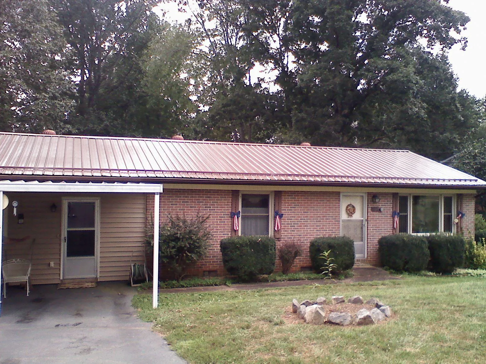 Bronze metal roof and carport on a brick ranch home — Roof Repair work by our crew in Jud